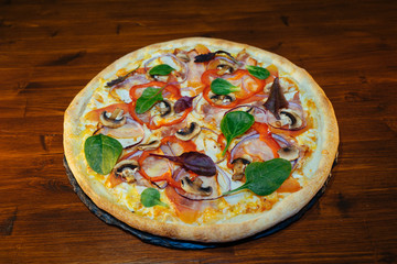 vegetarian Italian pizza with herbs and mushrooms and Basil on a wooden table