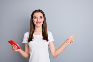 Portrait of her she nice-looking attractive lovely pretty cute curious cheerful cheery straight-haired girl using cell demonstrating copy space isolated over grey pastel color background