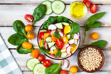 Concept of healthy food, clean eating, dieting. Colorful fresh vegetable salad in a bowl. Easy to cook, perfect summer light meal. Wooden background flat lay top view