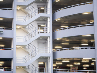 walking stair on the side of a white multi storey parking lots building