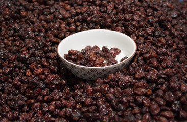 Bowl of raisins on raisins background