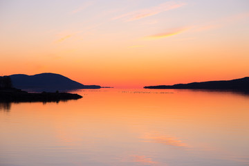 East view of the St. Lawrence River just before sunrise, with Cape Tourmente and the Island of Orleans seen in silhouette from Sainte-Anne-de-Beaupr&eacute;, Quebec, Canada