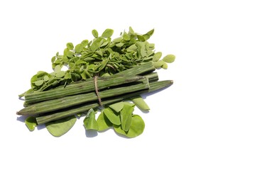 Heap of Drumstick Pods and Moringa Oleifera Leaves Isolated on White Background with Copy Space in Horizontal Orientation, Also Known as Horseradish