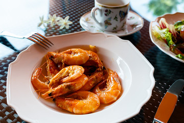 delicious lunch of fried shrimp with garlic, green salad , a cup of coffee