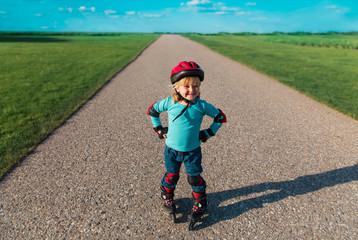 Fototapeta premium little girl on roller skates outdoors, kid exercise
