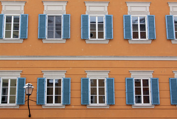 Fototapeta na wymiar Many identical windows on orange building facade