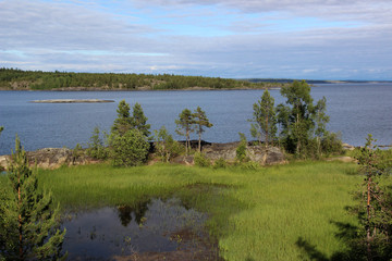 Summer lake with rocky shores in the forest