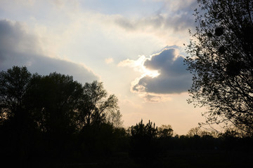 Fototapeta na wymiar The sun behind the clouds at sunset.