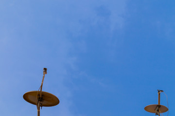 Two satellite antennas with space on blue sky. Background.