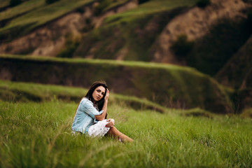young beautiful girl on a background of green hills