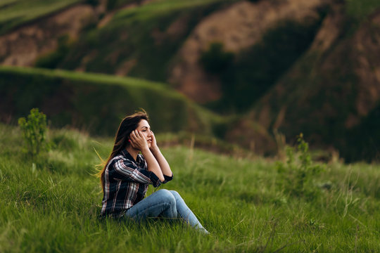 young beautiful girl on a background of green hills