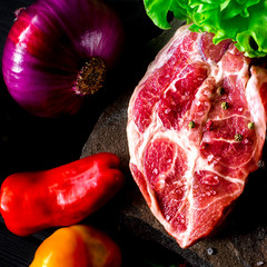 Two fresh raw ribeye steak on the stone on wooden background with salt, pepper