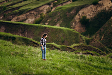 young beautiful girl on a background of green hills