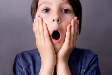 Child, boy, showing different emotions, isoalted shot on gray