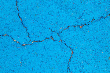 Blue color painting in cracked concrete textured background