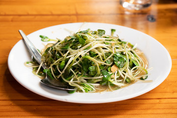 Fried sunflower sprout on white dish background
