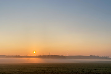 Sunrise over a meadow with ground fog
