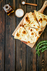 Italian focaccia with cheese and rosemary on dark wooden background top-down copy space