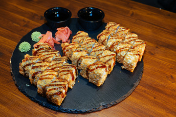 A set of sushi. Philadelphia roll, California, unagi, black dragon with fresh ingredients. The sushi menu. Japanese cuisine. Ginger and wasabi. Soy sauce. Sesame. Hot, baked, breaded