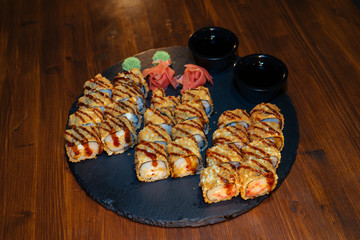 A set of sushi. Philadelphia roll, California, unagi, black dragon with fresh ingredients. The sushi menu. Japanese cuisine. Ginger and wasabi. Soy sauce. Sesame. Hot, baked, breaded