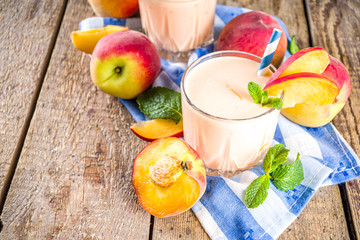 Summer breakfast drink, fresh blended peach smoothie, peach yogurt with nectarine fruit slices,...