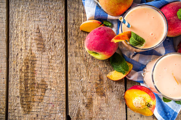 Naklejka na ściany i meble Summer breakfast drink, fresh blended peach smoothie, peach yogurt with nectarine fruit slices, rustic wooden background copy space