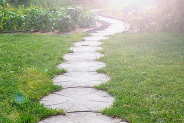 Garden stone path with grass growing up between the stones