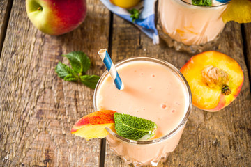 Summer breakfast drink, fresh blended peach smoothie, peach yogurt with nectarine fruit slices,...