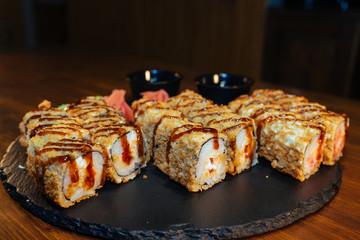 A set of sushi. Philadelphia roll, California, unagi, black dragon with fresh ingredients. The sushi menu. Japanese cuisine. Ginger and wasabi. Soy sauce. Sesame. Hot, baked, breaded