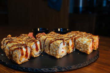 A set of sushi. Philadelphia roll, California, unagi, black dragon with fresh ingredients. The sushi menu. Japanese cuisine. Ginger and wasabi. Soy sauce. Sesame. Hot, baked, breaded