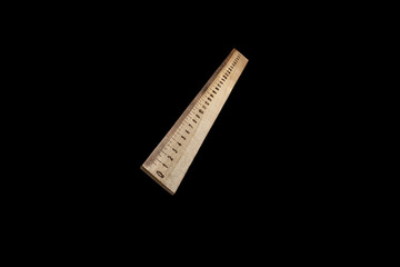 Wooden ruler isolated on black background. A 30 cm wooden ruler.