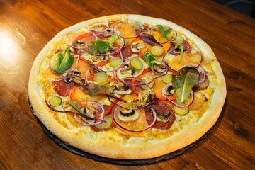 Italian pizza with mushrooms and herbs on a wooden table