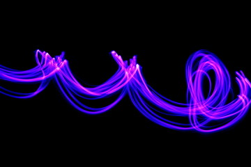 Long exposure photograph of neon purple colour in an abstract swirl, parallel lines pattern against a black background. Light painting photography.