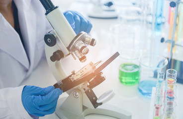 Medical research scientist using the microscope in chemical lap
