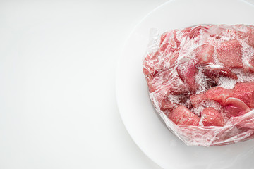 Bag of frozen meat. Frost formed on the pieces of meat