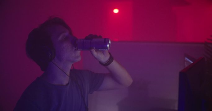 Man drinking energy drink playing video games