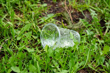 Disposable dishes on the grass. Concept of environmental pollution.