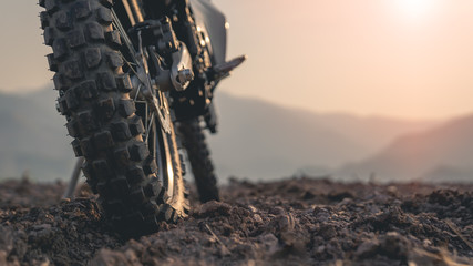 Part of a motocross wheel on a mound, the background is a mountain with sunrise.copyspace for your...