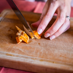 woman hands chopping chanterelle mushrooms on a cutting board (Cantharellus cibarius)