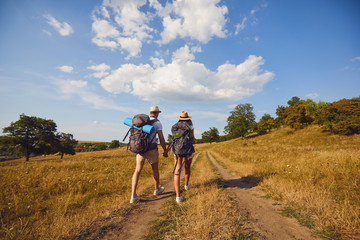 Fototapeta na wymiar Hiking couple with backpack walking on hike in nature
