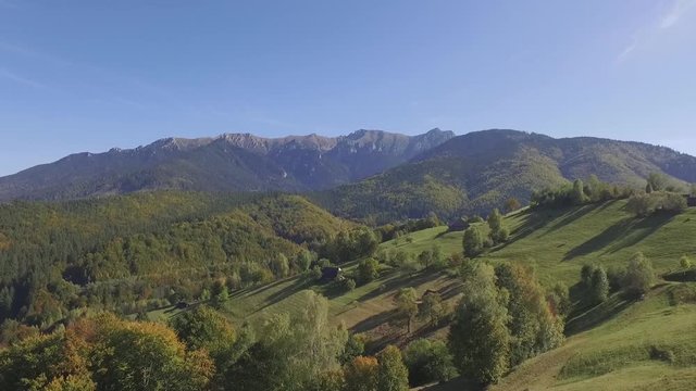 Aerial views of the scenic rural landscape surrounded by Carpathian Mountains and beautiful fresh green forests in the Brasov County, one of the most attractive tourist destinations in Romania