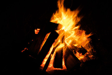 a campfire for a picnic that burns at night. Soft focus on the bars of wood