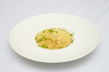 Soup with egg and meat, on a large white plate, white background