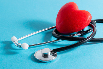Red heart and medical stethoscope on blue background close up. Health care concept. World Heart Day...