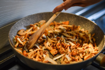 stirring mushrooms and onions while cooking close up