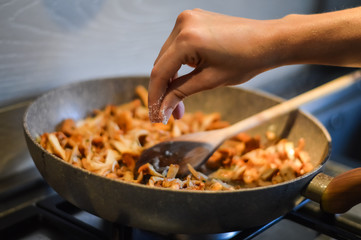seasoning cooking mushrooms and onions
