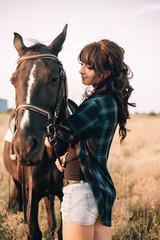 Obraz premium Young woman with her horse in evening sunset light. Outdoor photography with fashion model girl. Lifestyle mood