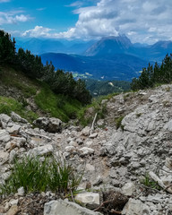 Dramatic vintage view of difficult rocky trekking trail to the mountain peak and valley in background at Seefeld