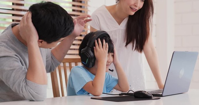 Father and mother playing game with they son at home. They playing game with funny emotion together. Lifestyle, Technology and Family concept.