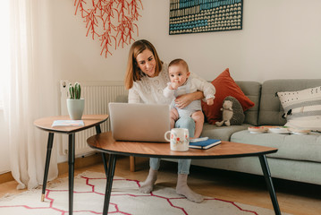 young business mother works from home with her cute baby